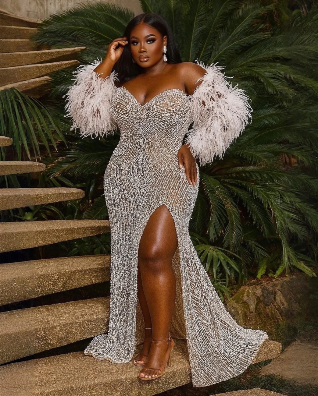 A bride in a beaded gown photographed on garden steps